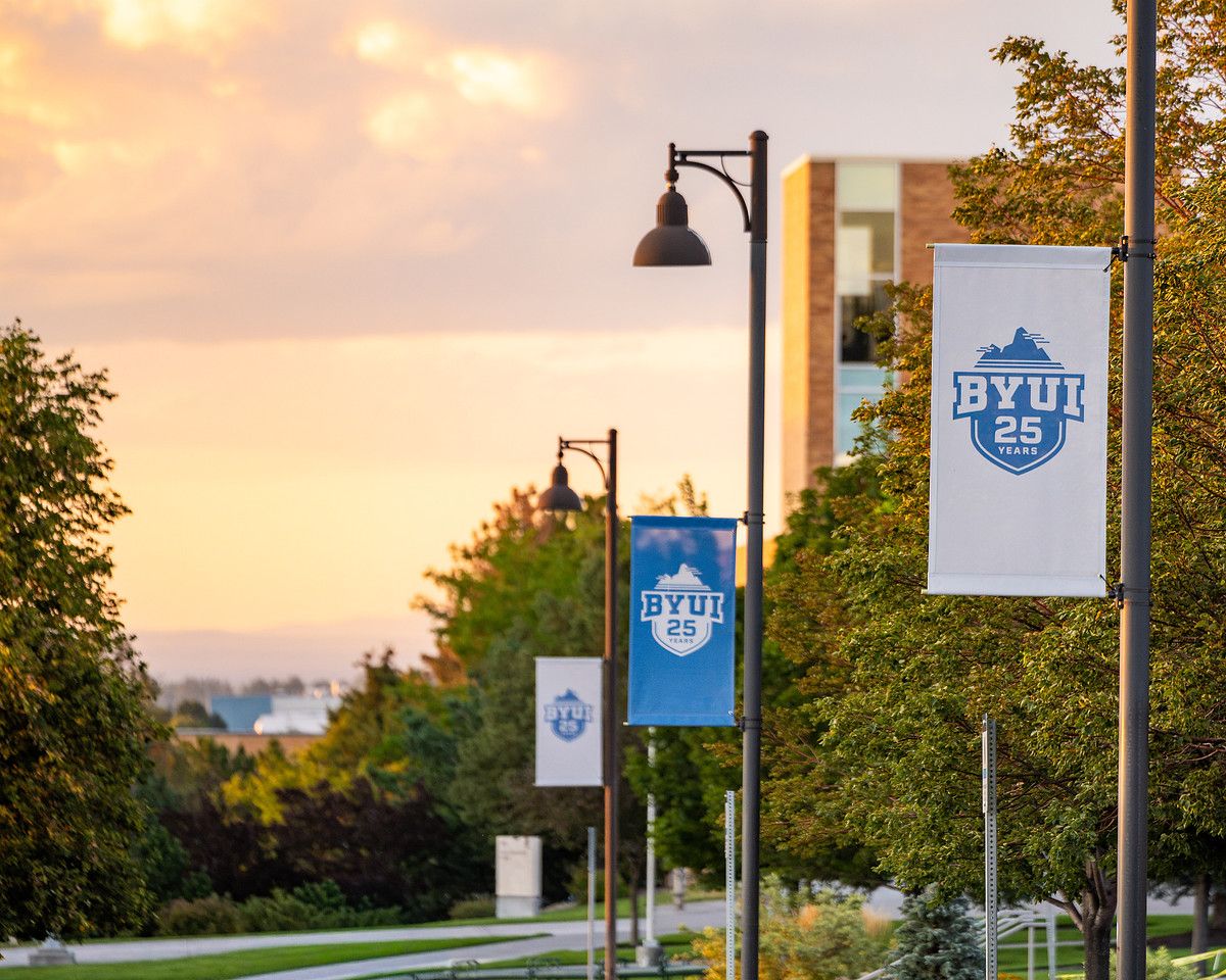 BYU-Idaho banners along a campus walkway at sunset