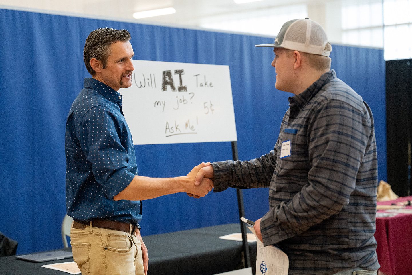 A student shakes hands with a recruiter at the STEM Career Fair